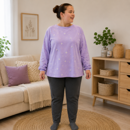 Vrouw draagt T-shirt Jumpy met lila bloemen bovenstuk en donkergrijze broek